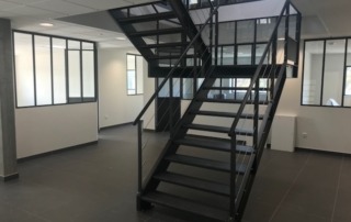 Aménagement de bureaux avec escalier et verrière en métal
